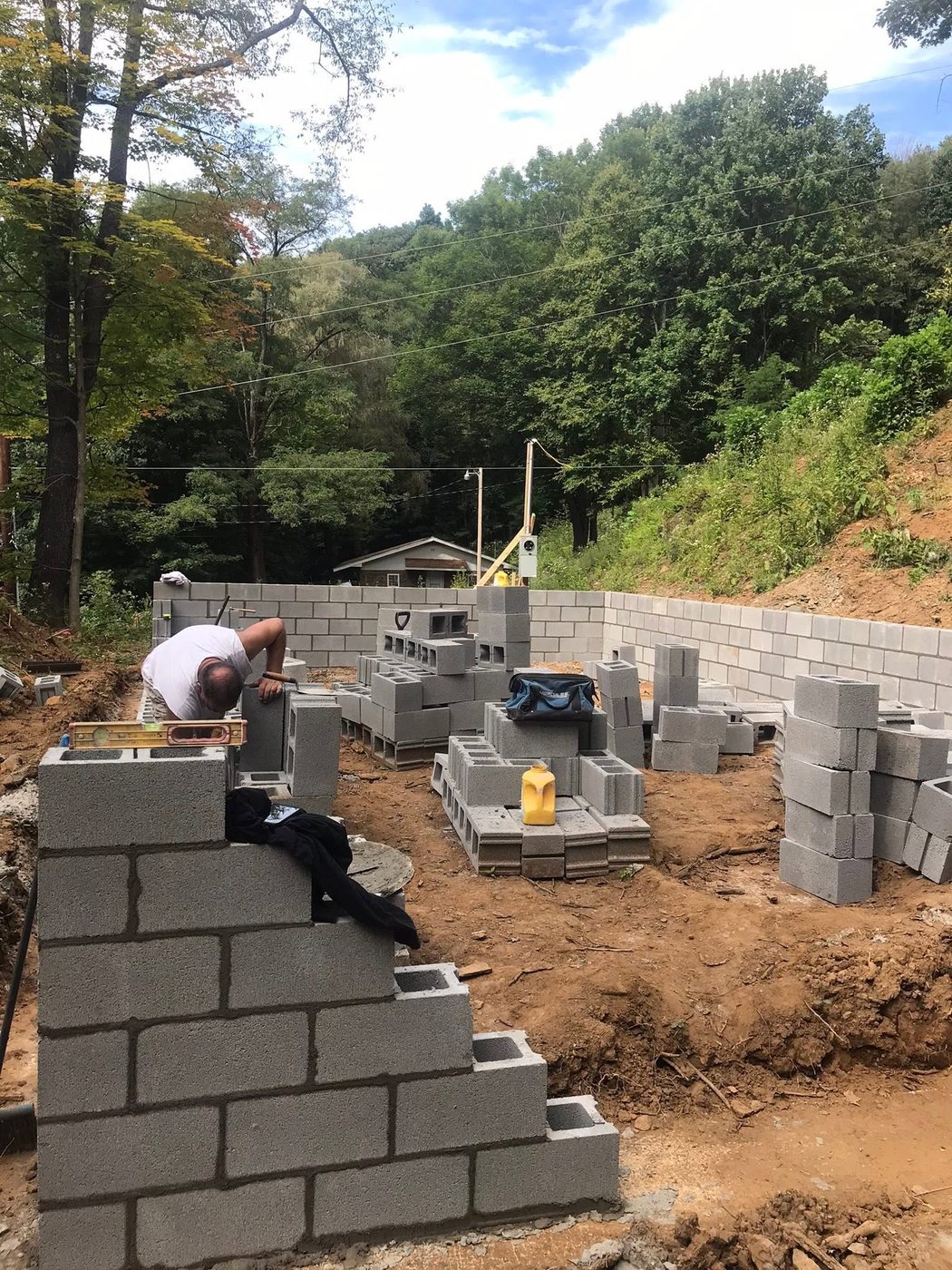 A block foundation wall being laid by hand