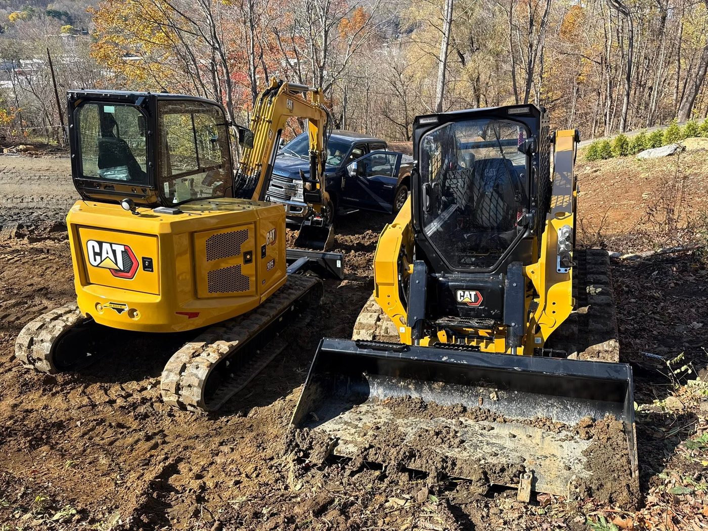 An excavator and skid steer working on a site
